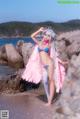 A woman in a bikini standing on a beach.