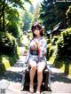 A woman in a kimono sitting on a bench in a park.