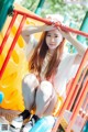 A young woman sitting on a playground slide.