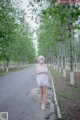 A woman in a white dress standing in the middle of a road.