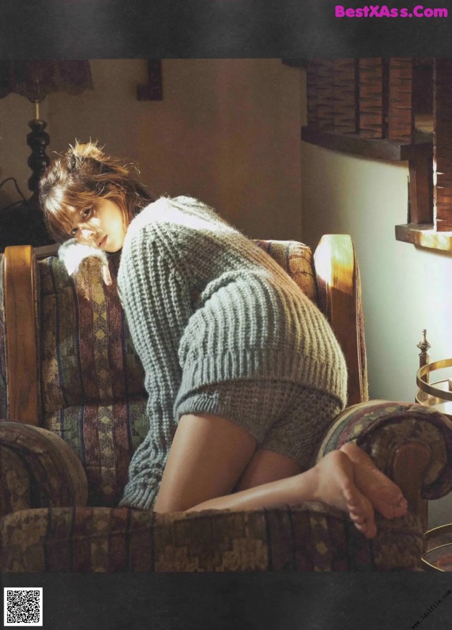 A woman sitting on a chair in a room.