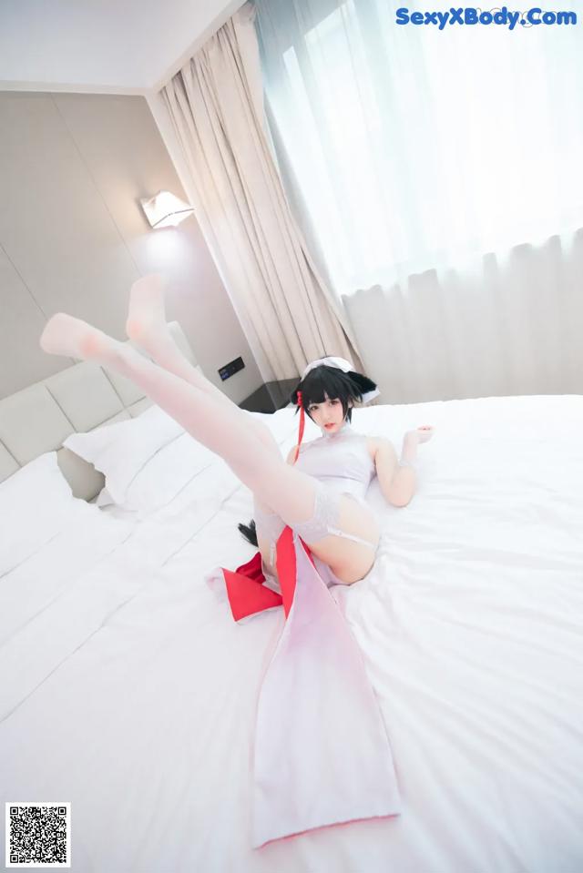 A woman laying on top of a bed in a room.