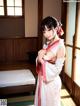 A woman in a white kimono standing in a room.