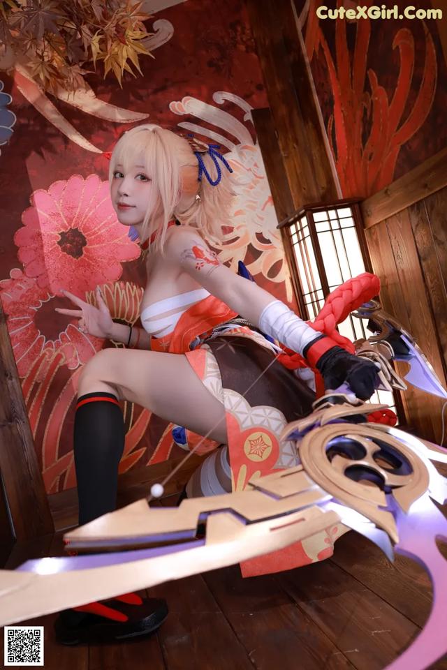 A woman in a cosplay outfit holding a sword.