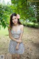 A woman in a floral dress posing for a picture.