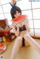 A woman sitting on the floor eating a slice of watermelon.