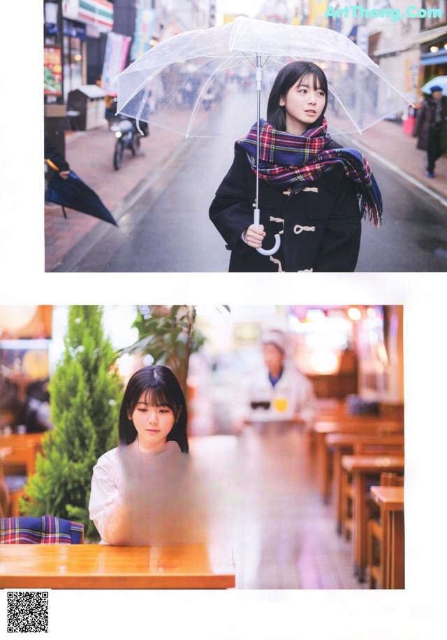 A woman holding an umbrella while sitting at a table.