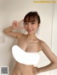 A woman in a white bra top posing for the camera.