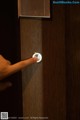 A person is pressing a button on a wooden door.